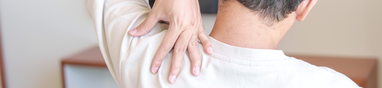 SLAP Q&A 섹션: 밝은 베이지색 상의를 입은 사람이 팔을 들어 올려 손으로 어깨 뒤쪽을 짚고 있는 뒷모습 사진